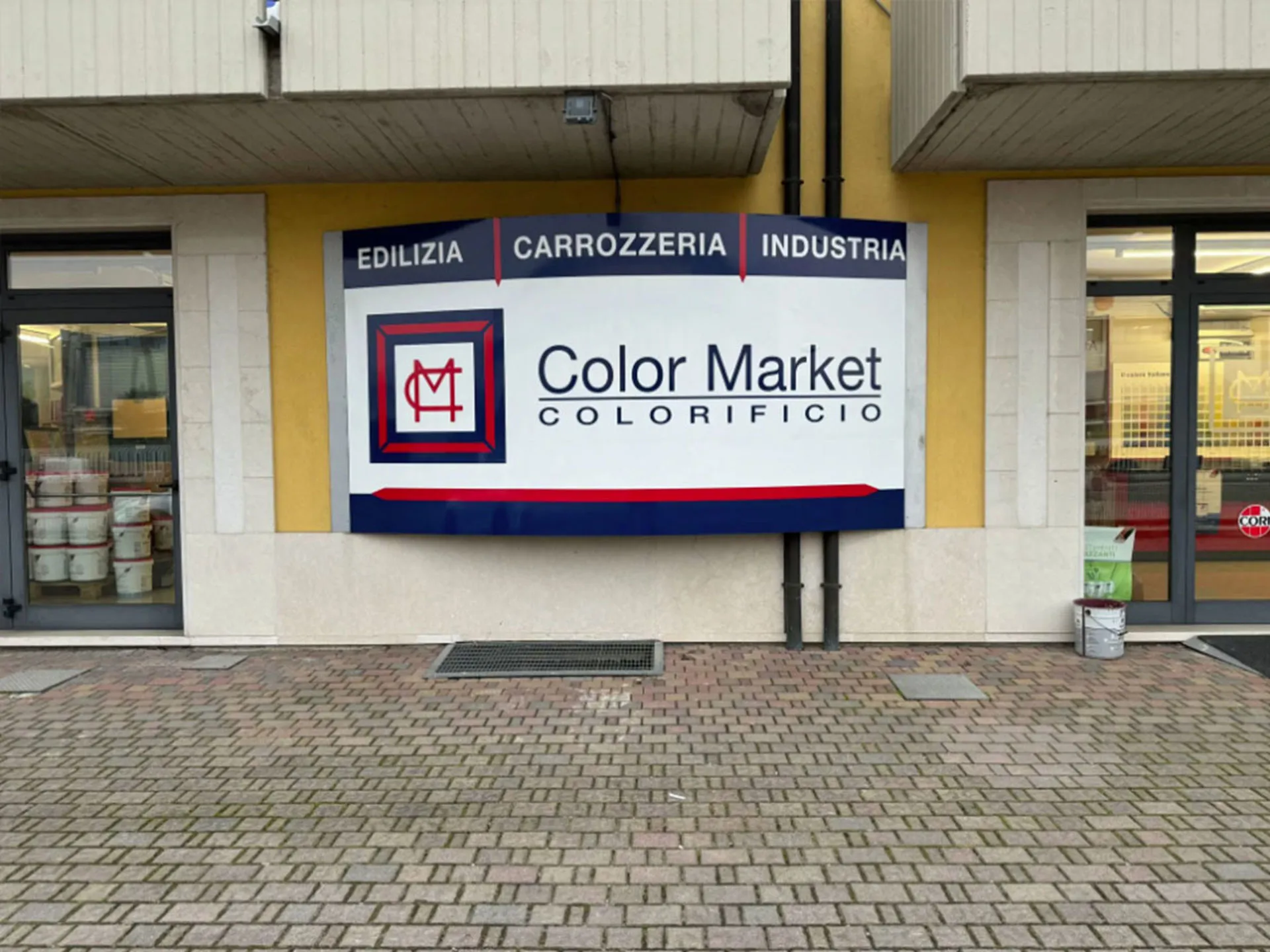 Pittura blu sul muro con mano che tiene un pennello